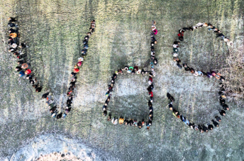 Luftaufnahme einer Menschenmenge, die auf einer Wiese die Buchstaben ‚vds‘ formt. Die Personen stehen dicht nebeneinander, sodass die Buchstaben gut lesbar sind. Die Aktion wirkt gemeinschaftlich und symbolisiert Zusammenhalt und Identifikation mit dem Verband.